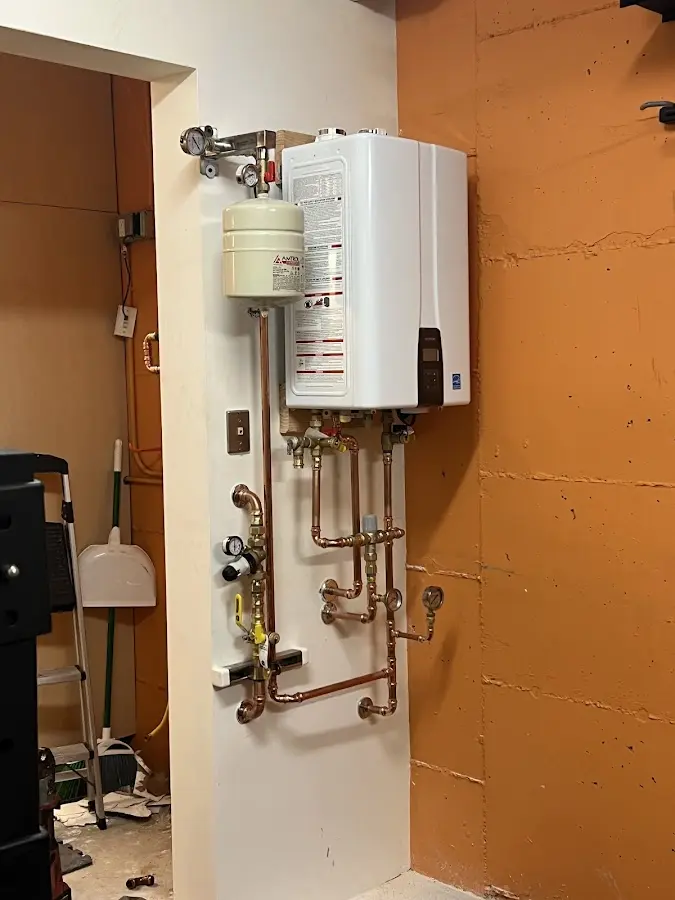 Plumbing technician inspecting water heater connections in Hogansville